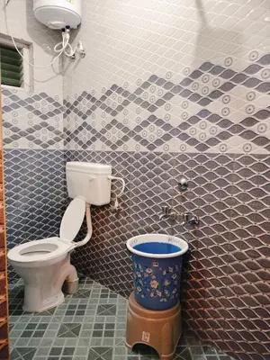 a bathroom with a toilet and a bucket in it at Harvest Hill View Cottage in Ooty
