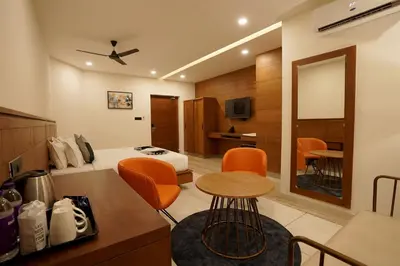 a room with a bed and a table and chairs at Stayon Hotels in Palakkad