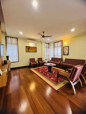 a living room with chairs and a table and a couch at Yemcee Rivera in Tellicherry