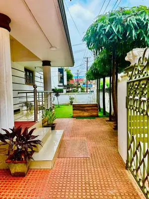 a patio with a bench and a fence with a tree at K K Gardens in Palakkad