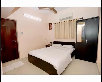 a bedroom with a large bed with white sheets at K K Gardens in Palakkad