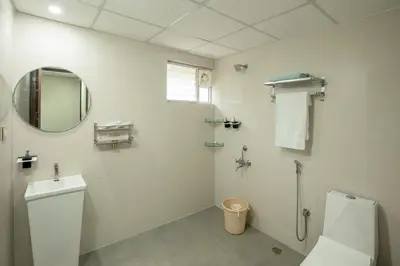 a white bathroom with a toilet and a mirror at Encanto Farmstay Resort in Mysore