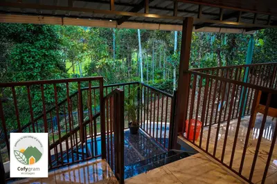 a balcony with a view of a forest at Cofygram cottages in Wayanad