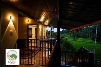 a house with a balcony with a view of a yard at Cofygram cottages in Wayanad