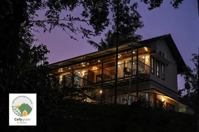a large house with lights on it at night at Cofygram cottages in Wayanad