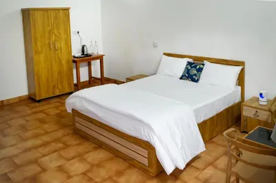a bedroom with a large bed and a wooden cabinet at Cozy Haven Homestay in Meenangadi