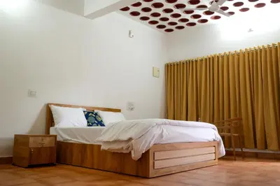 a bedroom with a bed and a window with curtains at Cozy Haven Homestay in Meenangadi