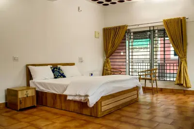 a bedroom with a large bed and a window at Cozy Haven Homestay in Meenangadi
