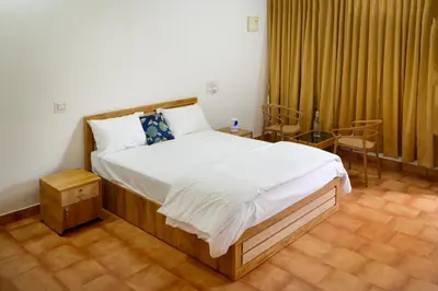 a bedroom with a bed and a table and chairs at Cozy Haven Homestay in Meenangadi