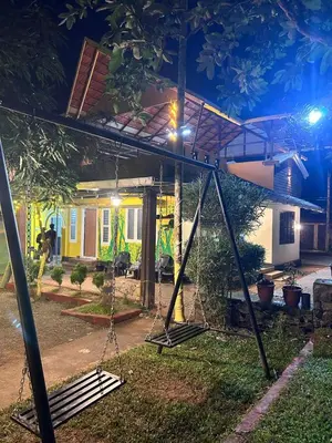 a swing set in front of a house at night at Wild Villa Homestay in Sultan Bathery
