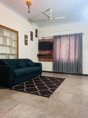 a living room with a green couch and a tv at Wild Villa Homestay in Sultan Bathery