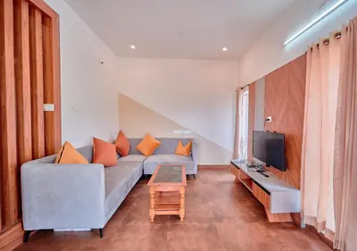 a living room with a couch and a tv at Cucuu Nest Villa Coonoor by VOYE HOMES - Surrounded by Tea Plantations in Coonoor