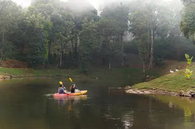 two people in a kayak on a river at Jungle Park Resort-Rain Forest Experience by GreenEscapes in Vythiri