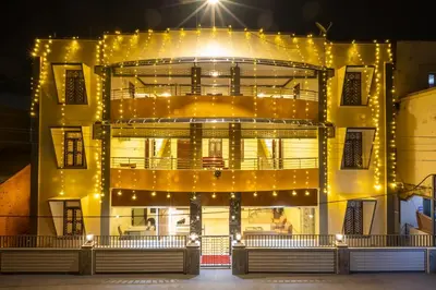 a large yellow building with lights on it at The Modern Inn in Pollāchi