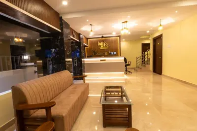 a living room with a couch and a table at The Modern Inn in Pollāchi