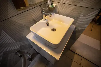 a white sink in a bathroom with a shower at The Modern Inn in Pollāchi