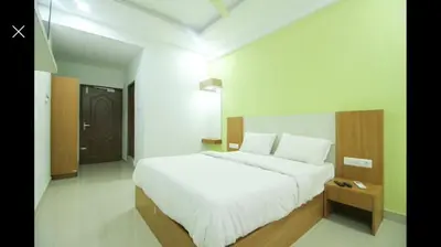 a bedroom with a large white bed and a table at PLAZA RESIDENCY and CONFERENCE HALL in Malappuram