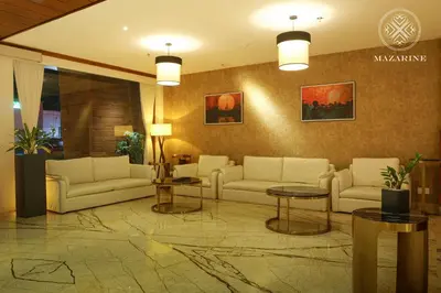 a lobby with couches and tables in a building at Mazarine Hotels & Resorts LLP in Kalpetta