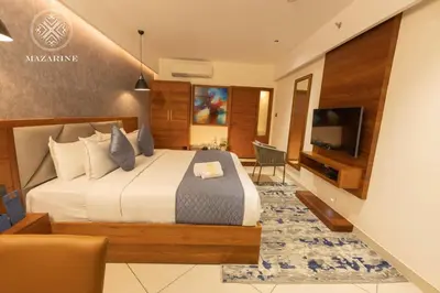 a hotel room with a bed and a television at Mazarine Hotels & Resorts LLP in Kalpetta