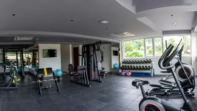 a gym with a lot of treadmills and exercise equipment at Mazarine Hotels & Resorts LLP in Kalpetta