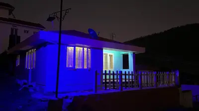 a house lit up in blue at night at Mountain melody cottages in Ooty