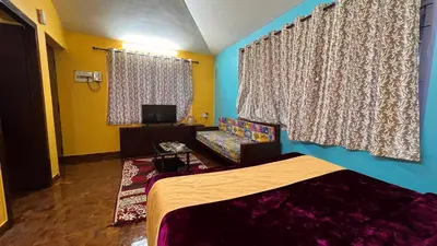 a bedroom with a bed and a couch and a window at Mountain melody cottages in Ooty