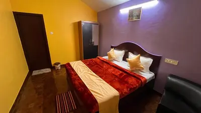 a bedroom with a bed with a red comforter at Mountain melody cottages in Ooty