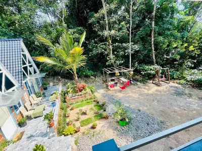 an aerial view of a garden with plants and a swing at LAKSHMI NIKUNj Estate Stay in Madikeri
