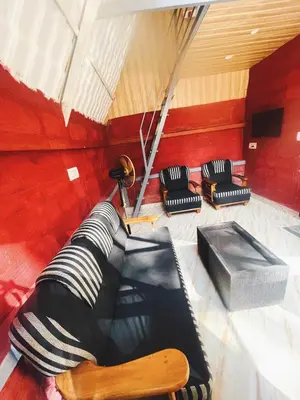 a room with three chairs and an umbrella at LAKSHMI NIKUNj Estate Stay in Madikeri