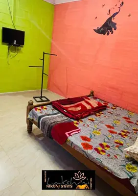 a bedroom with a bed with a colorful wall at LAKSHMI NIKUNj Estate Stay in Madikeri