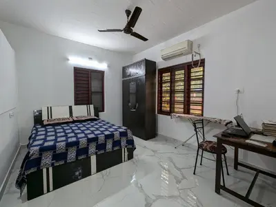 a bedroom with a bed and a desk in it at Thekkumkattil Villa in Nedumbassery