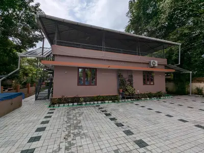 a small pink house with a pitched roof at Thekkumkattil Villa in Nedumbassery