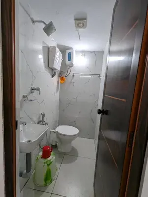 a small bathroom with a toilet and a sink at Thekkumkattil Villa in Nedumbassery