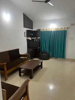 a living room with a couch and a table at GURI Homestay in Kushālnagar