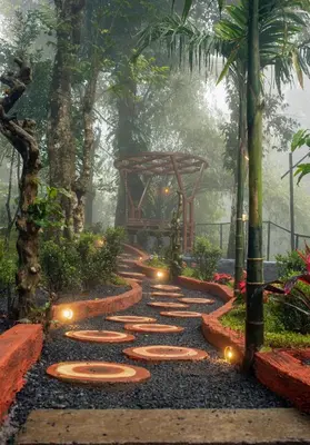 a walkway in a garden with lights on it at Hunters Hideout Resort in Wayanad