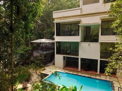 an aerial view of a building with a swimming pool at Hunters Hideout Resort in Wayanad