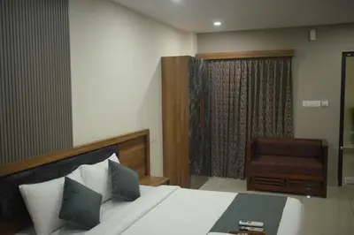 a hotel room with a bed and a chair at Cruz Inn calicut in Kozhikode
