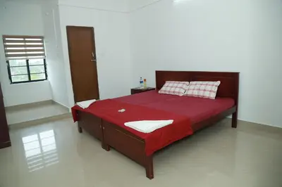 a bedroom with a large bed with a red blanket at Royal Park in Wayanad
