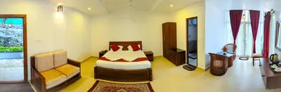 a bedroom with a bed and a couch in a room at VALLEY VIEW INN, Kotagiri in Kotagiri
