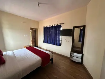 a hotel room with a bed and a television at Shivvs Heritage Resort Ooty in Ooty