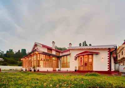 a large white house with a lot of windows at Shivvs Heritage Resort Ooty in Ooty
