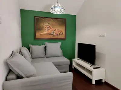 a living room with a couch and a television at Hideaway in Ooty