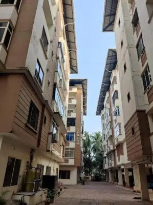 an empty street between two tall buildings at CC Family in Guruvāyūr