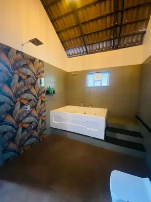 a bathroom with a white tub and a flower mural at SR Villa - Serenity by riverside in Meppādi