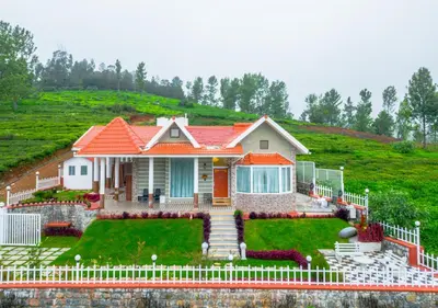 a house with an orange roof on a hill at EMYs Misty Charm Private Villa Ooty by VOYE HOMES in Ooty