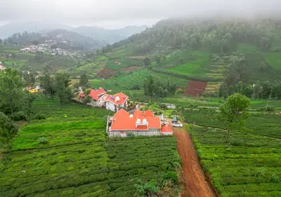 a house in the middle of a field of tea plantations at EMYs Misty Charm Private Villa Ooty by VOYE HOMES in Ooty
