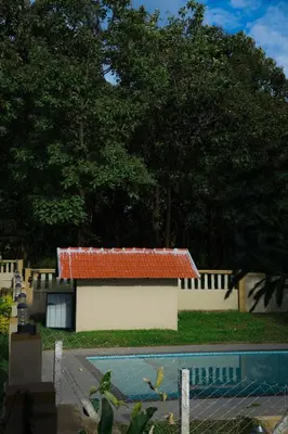 a building with a red roof next to a swimming pool at The Rain Tree resort in Kutta