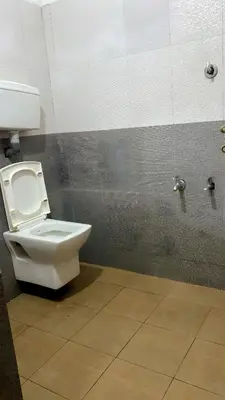 a bathroom with a white toilet in a stall at The Rain Tree resort in Kutta