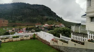 a balcony with a white fence and a mountain at The silver dale homestay 1 in Ooty