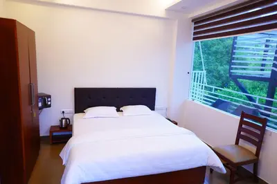 a bedroom with a large white bed and a window at Palatty's Resorts in Athirappally